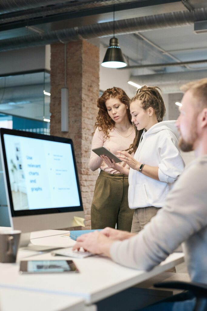 Young professionals collaborating in a modern office setting with digital devices.